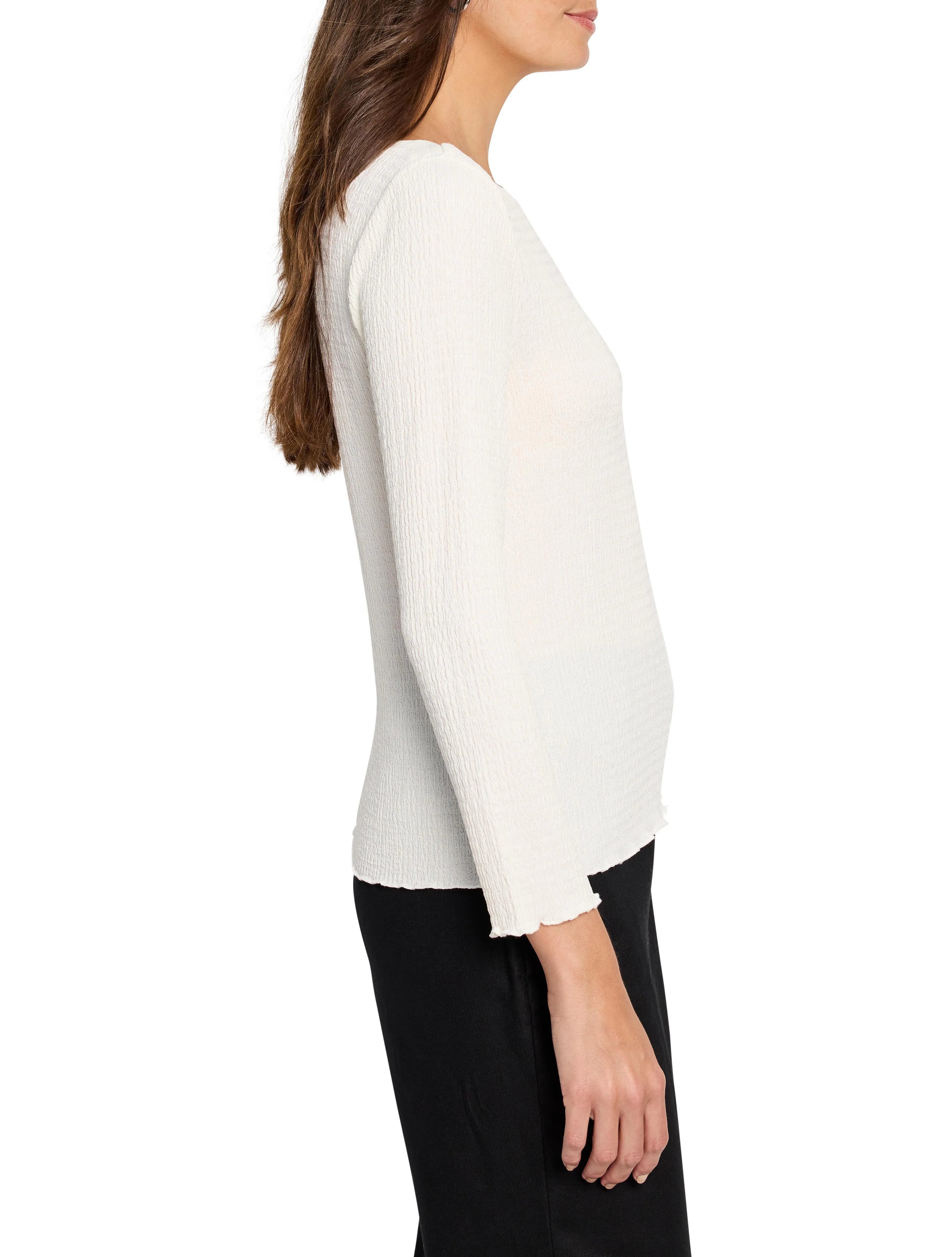 Cream bubble knit top with long sleeves, ruffled cuffs, and hem. Model is shown in profile.