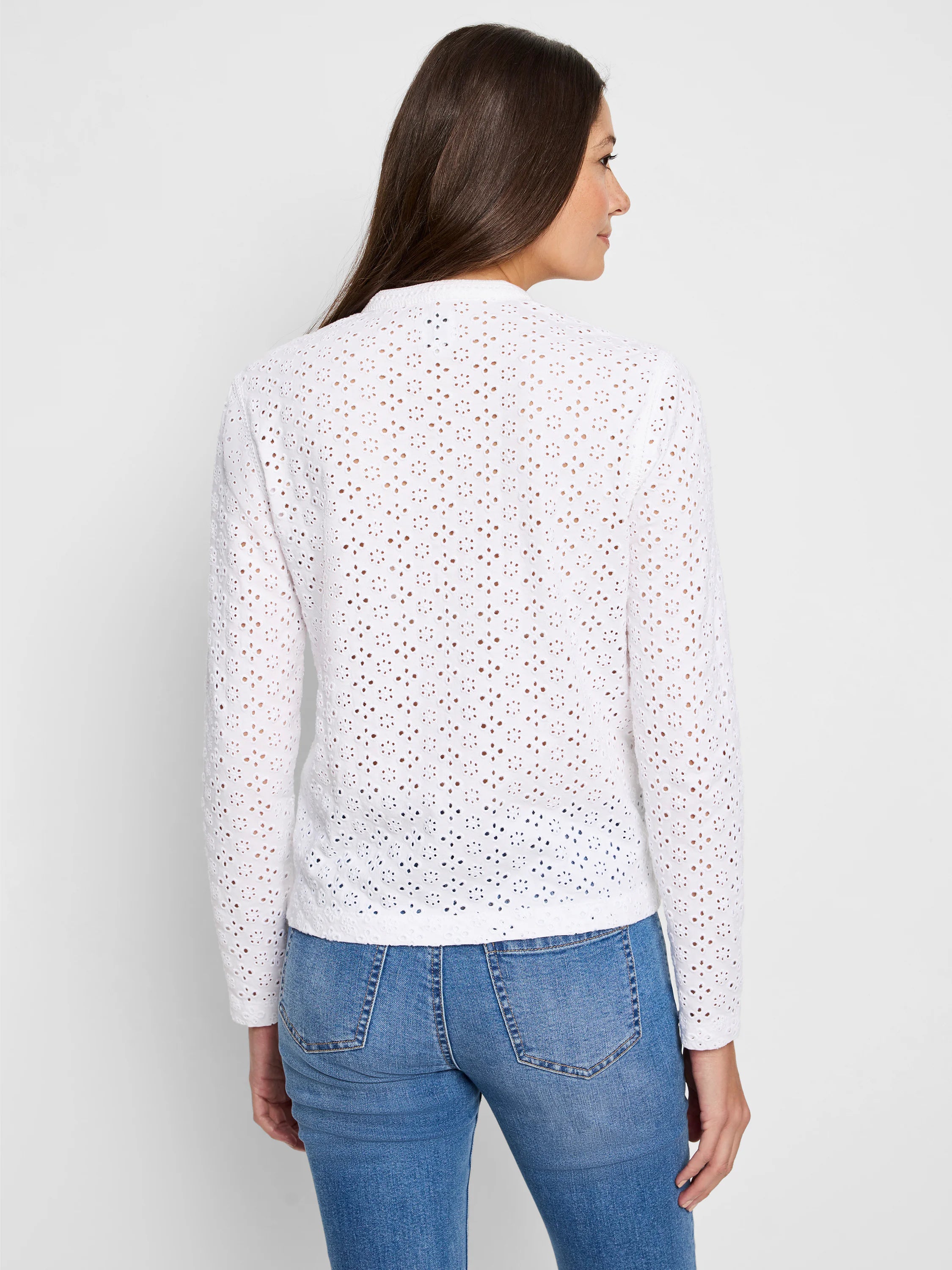 White eyelet knit long-sleeve top, covered in a floral perforated pattern.