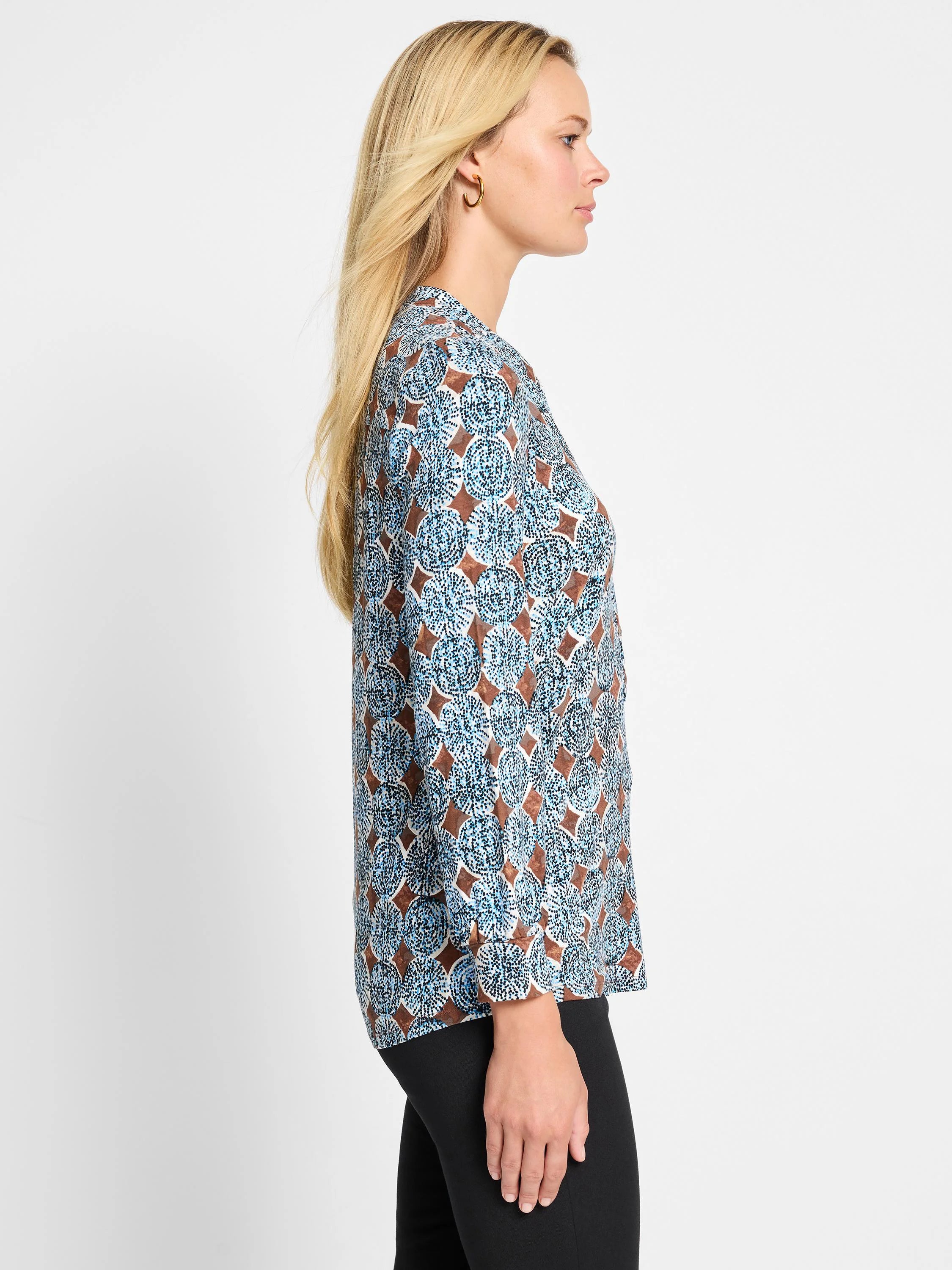 Brown and blue long-sleeved knit top with a pattern of dotted circles and solid diamond shapes.