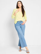 Pale yellow V-neck sweater with a subtle textured knit and long sleeves.