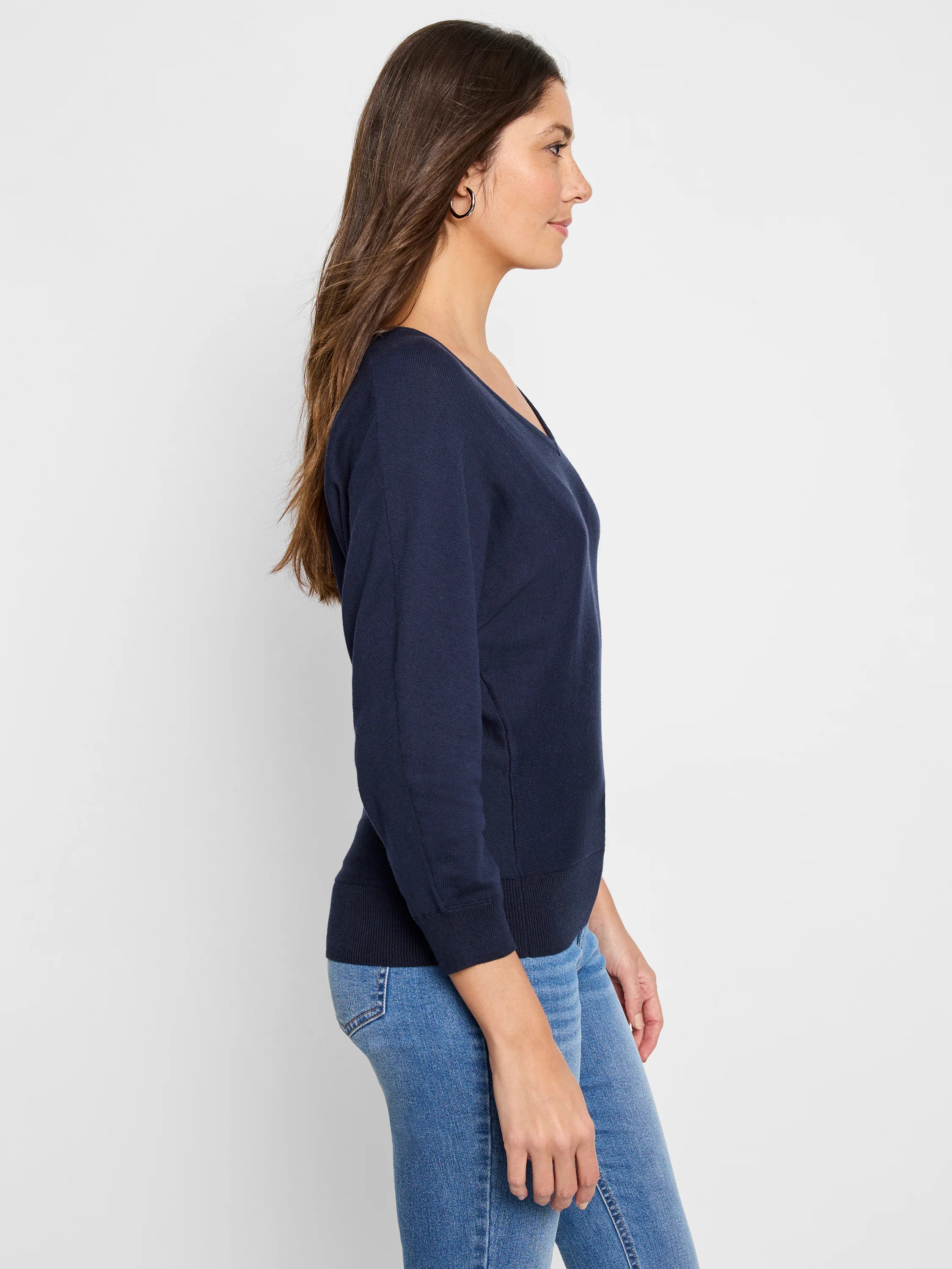 Navy blue V-neck sweater with long sleeves, ribbed cuffs and hem, modeled in profile.