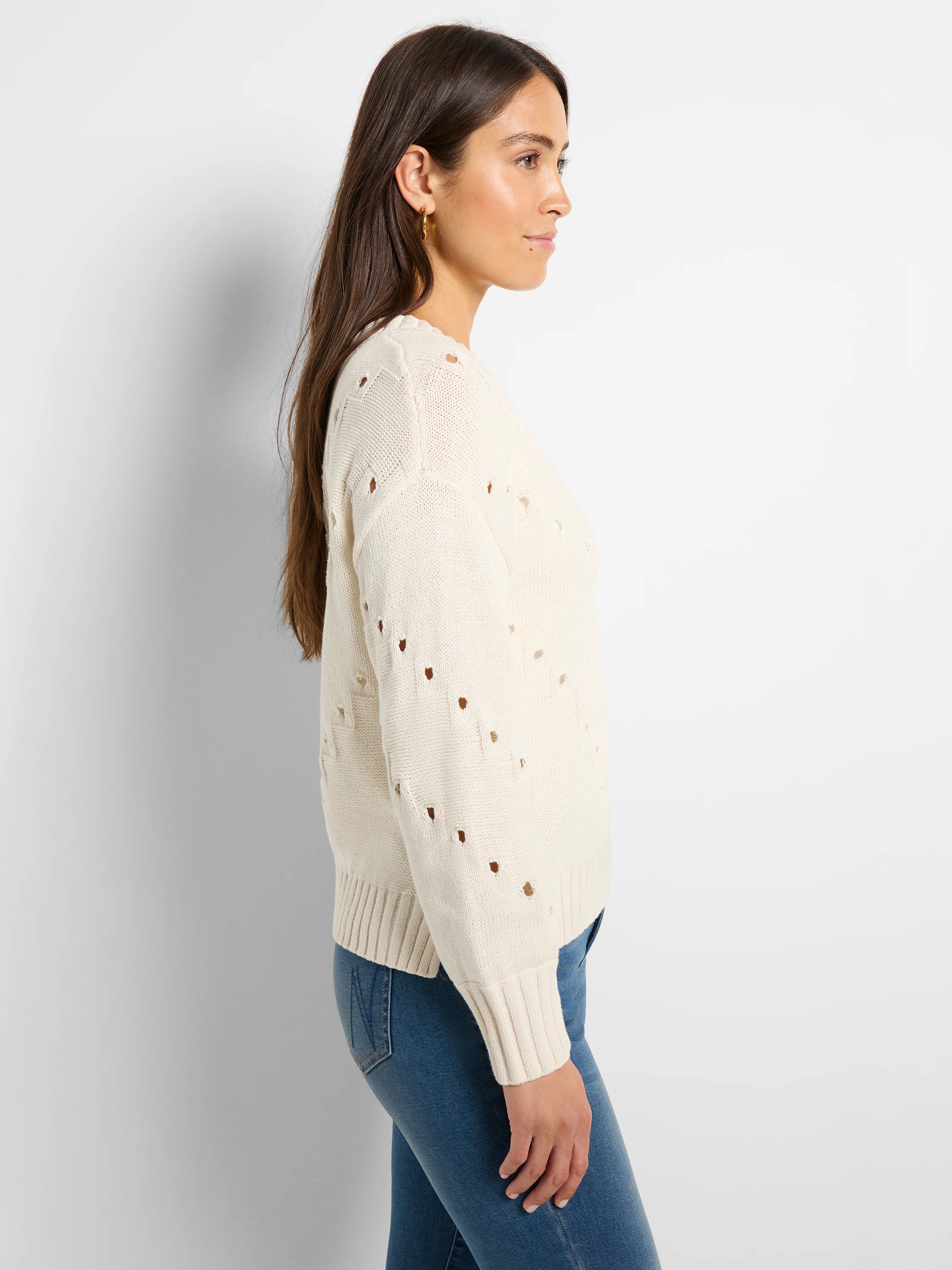 Off-white pointelle knit sweater with small open holes, ribbed cuffs and hem.