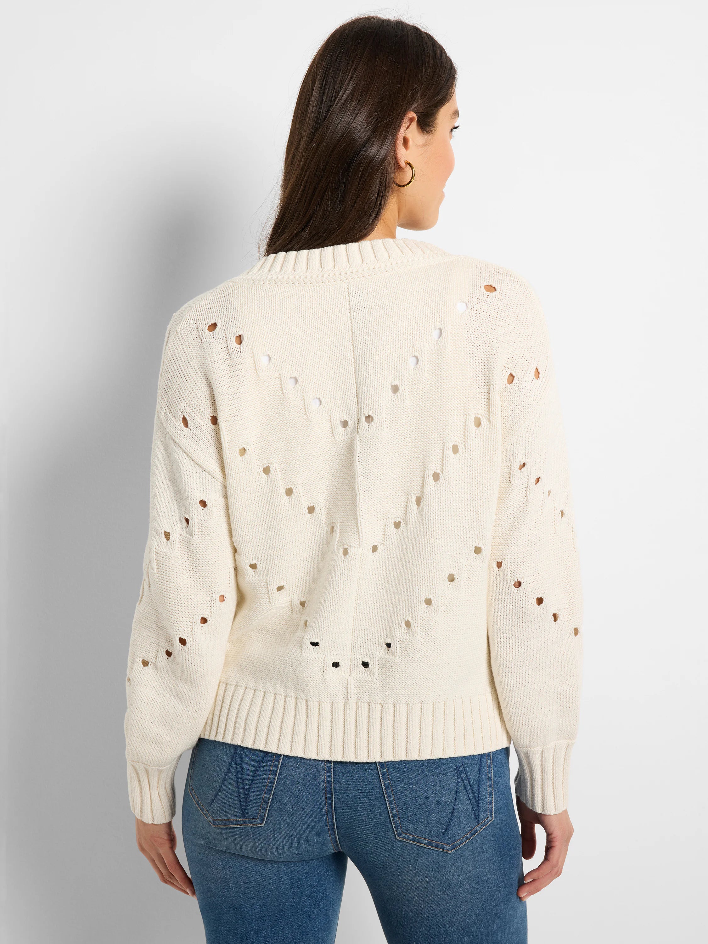 Cream knit sweater with a V-shaped pointelle pattern on the back.