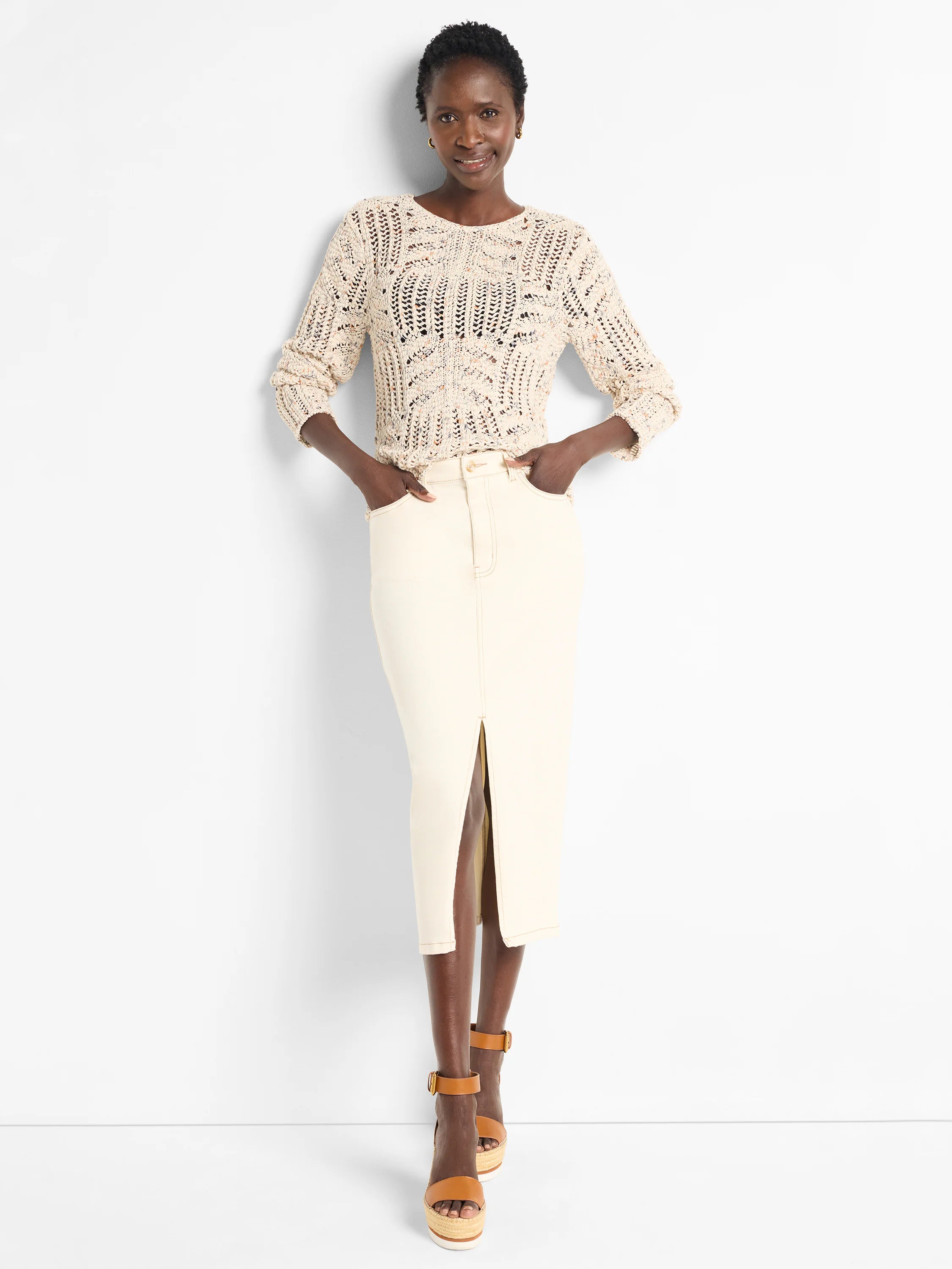 Cream open-knit sweater with small denim blue and brown flecks. Features a crew neck and long sleeves.