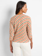 Textured knit sweater with diagonal stripes in coral, yellow, navy, and cream. Features 3/4 sleeves.