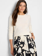 Off-white fine knit crew neck sweater with long sleeves, smooth body, ribbed cuffs and hem.