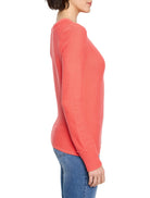 Muted coral garter knit crew neck sweater with long sleeves and ribbed cuffs, side view on model.