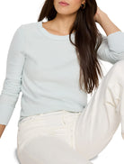 Pale blue crew neck sweater with long sleeves and ribbed cuffs.