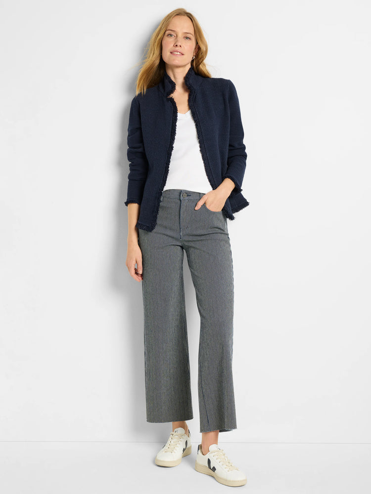 Navy blue knit jacket with fringe trim. Model wears it over a white top.