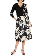 Black v-neck sweater with off-white abstract print on one side.  Paired with a black and off-white abstract print midi skirt.