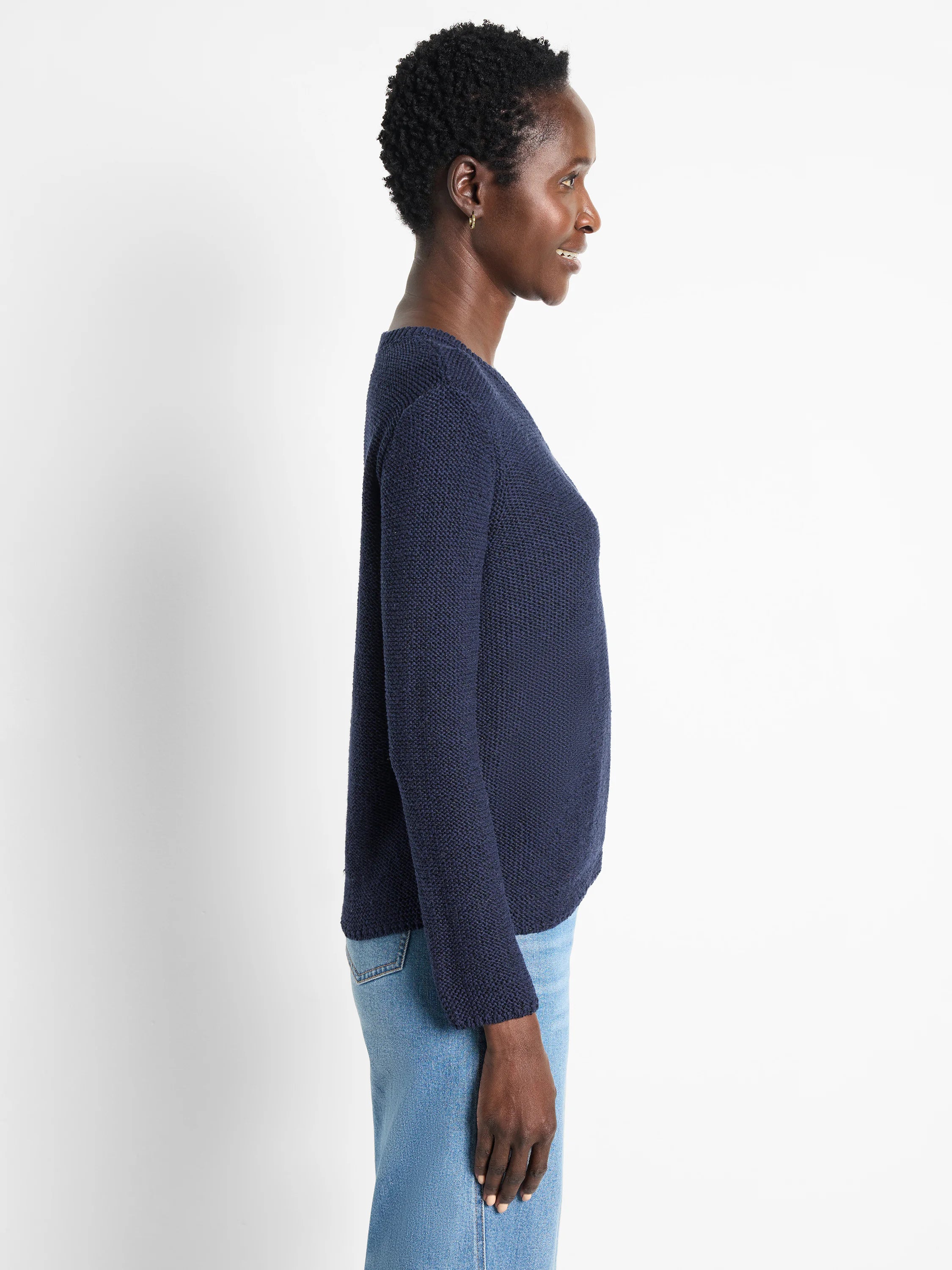 Navy blue, long-sleeved, textured knit sweater. Side profile shows relaxed fit.