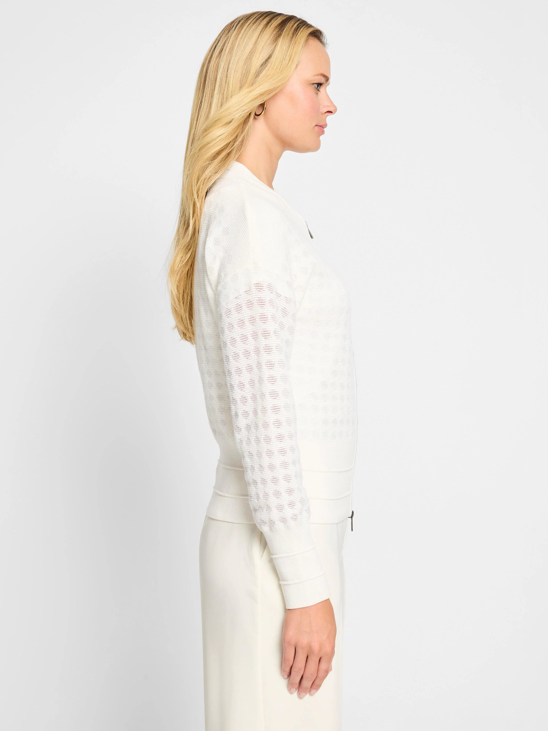 Off-white sheer knit cardigan.  Stitched pattern on sleeves.  Long sleeves, zip front.