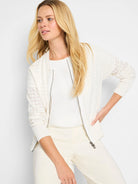 Off-white sheer knit cardigan with a front zipper.  Patterned sleeves, solid body.