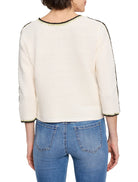 Off-white ribbed sweater with black and light green trim at neckline and sleeves.  Three-quarter sleeves.