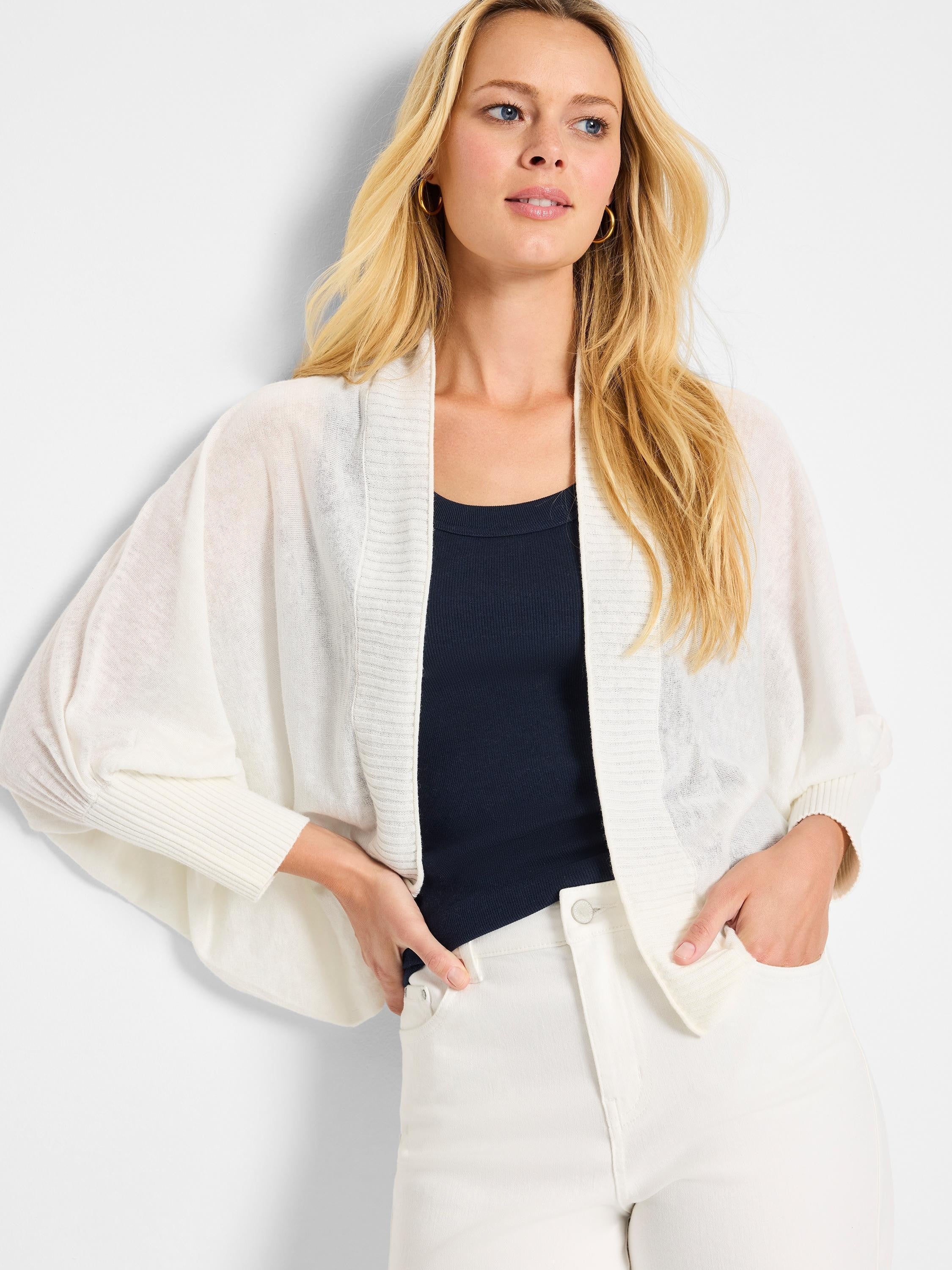 Off-white, open-front cardigan with three-quarter sleeves and ribbed detailing.  The sleeves are slightly puffed.