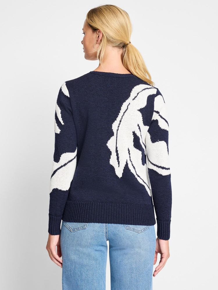 Navy blue sweater with an off-white abstract leaf pattern on the back. Long sleeves, ribbed cuffs and hem.