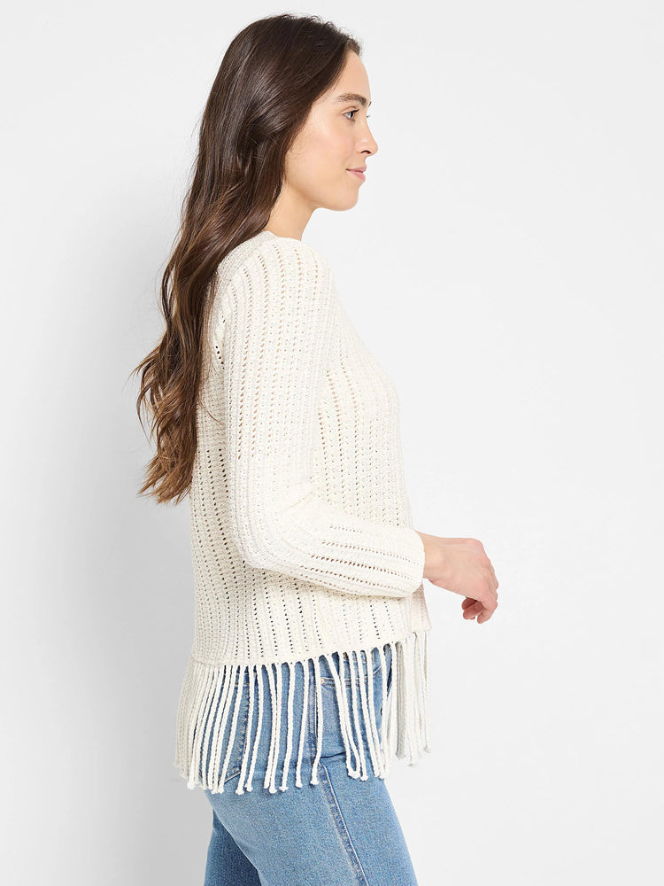 Off-white knit sweater with fringe bottom. Long sleeves, open knit pattern.