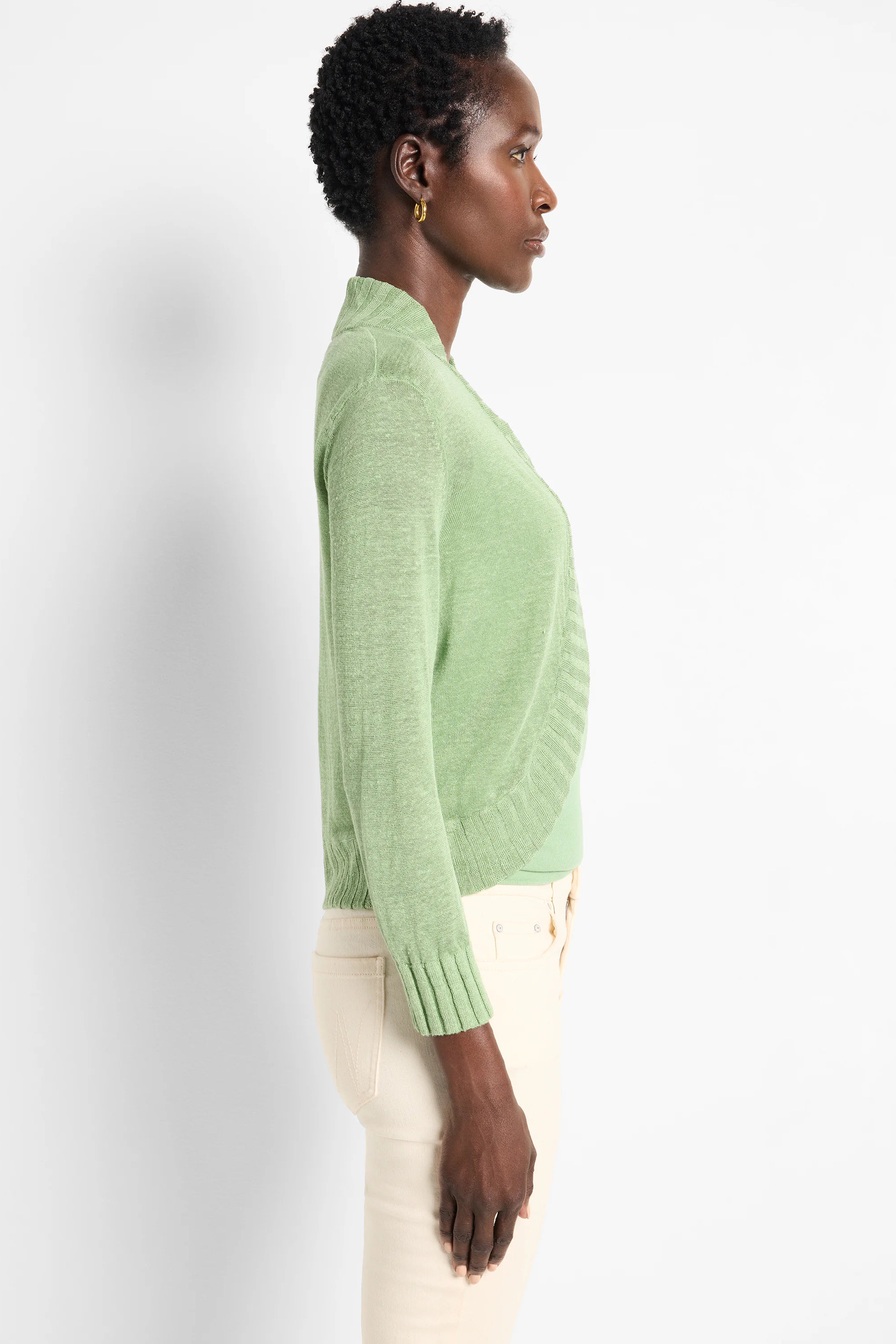 Light green bolero cardigan with a wrap front, long sleeves, and ribbed cuffs and hem on a model.