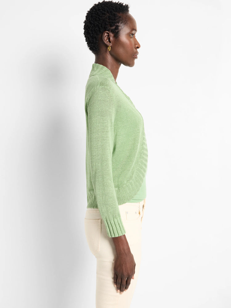 Light green bolero cardigan with a wrap front, long sleeves, and ribbed cuffs and hem on a model.