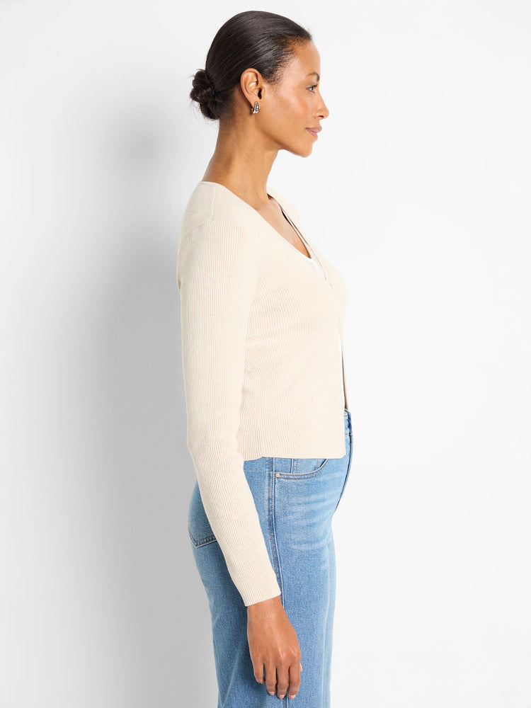 Off-white ribbed V-neck cardigan with long sleeves. It has a cropped length and is worn open.