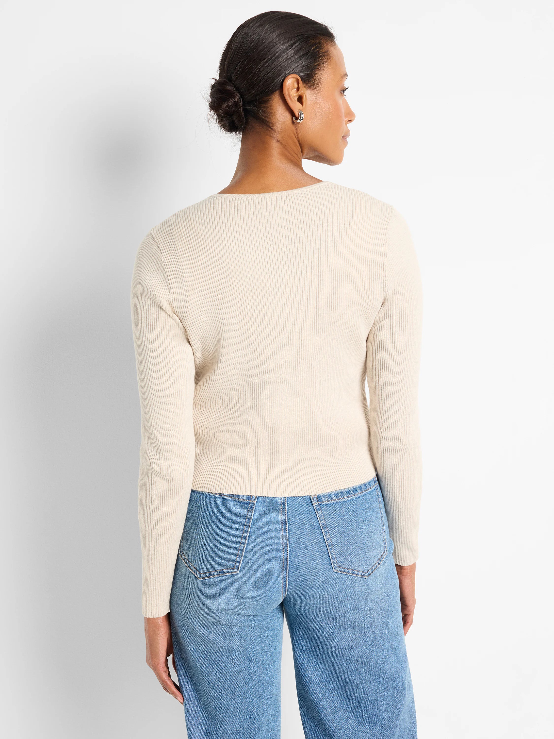 Cream ribbed knit long-sleeve cardigan on a model, viewed from behind.