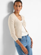 Cream ribbed knit V-neck cardigan with long sleeves and a single silver-toned decorative clasp. Waist-length.