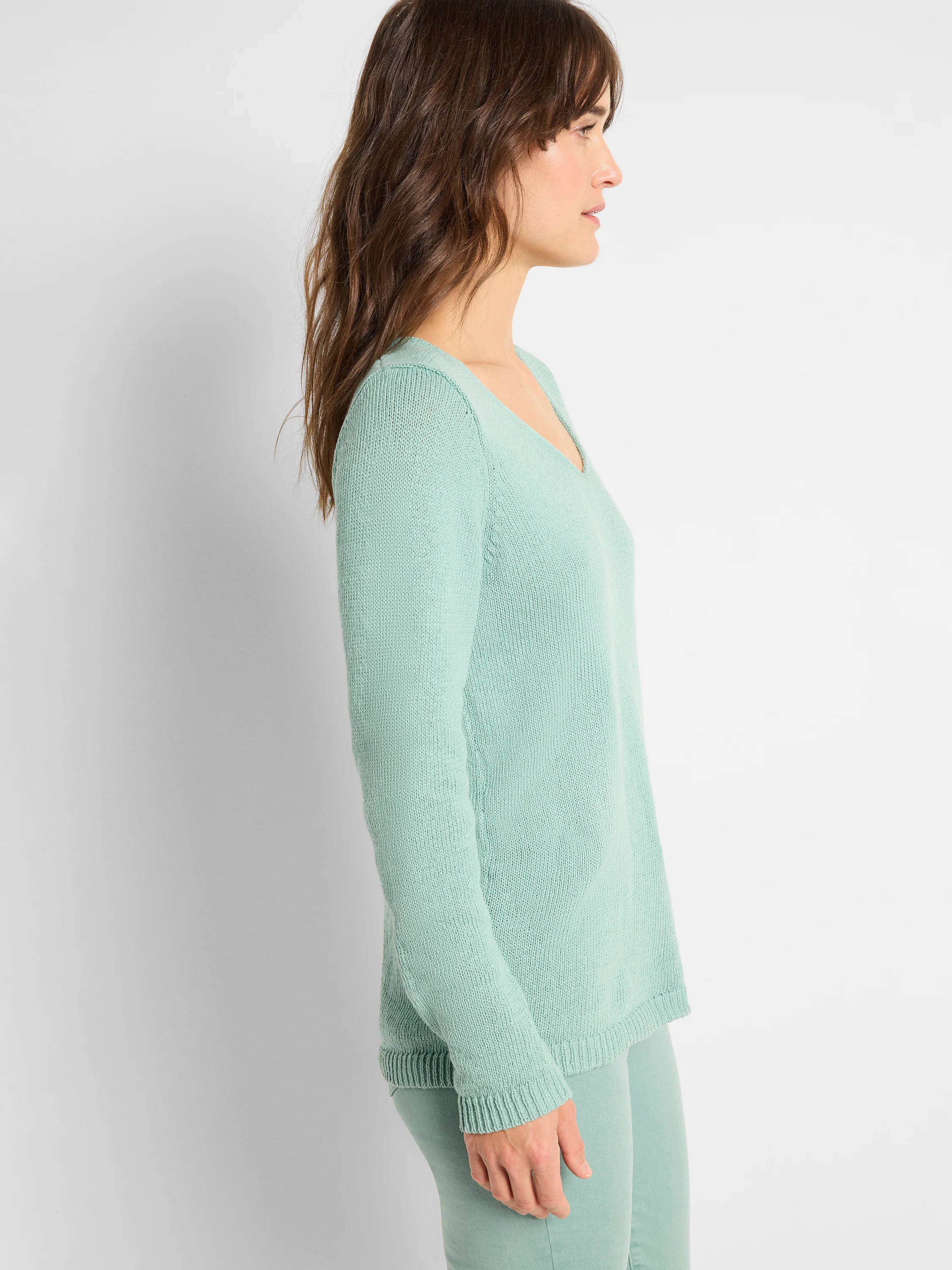 Mint green V-neck sweater with long sleeves, visible knit texture, and ribbed cuffs and hem.
