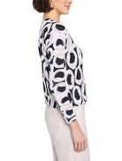 Off-white sweater with black and beige abstract circular pattern.  Three-quarter sleeves.