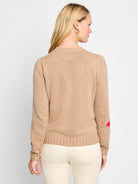 Beige sweater with red and black heart accents on the elbows.  Puff sleeves, ribbed cuffs and hem.