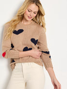 Beige sweater with dark blue hearts; red hearts on elbows.  Crew neck.