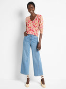 Beige sweater with pink and coral ikat pattern, V-neck.