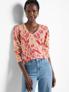 Beige sweater with pink and orange ikat pattern.  V-neck, long sleeves.