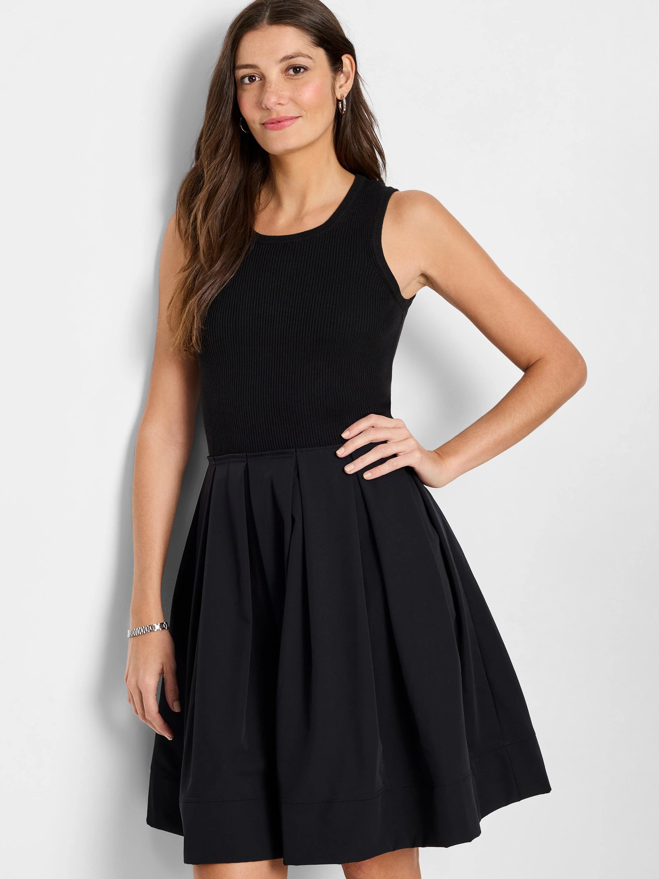 Black sleeveless ribbed knit top and pleated A-line skirt.
