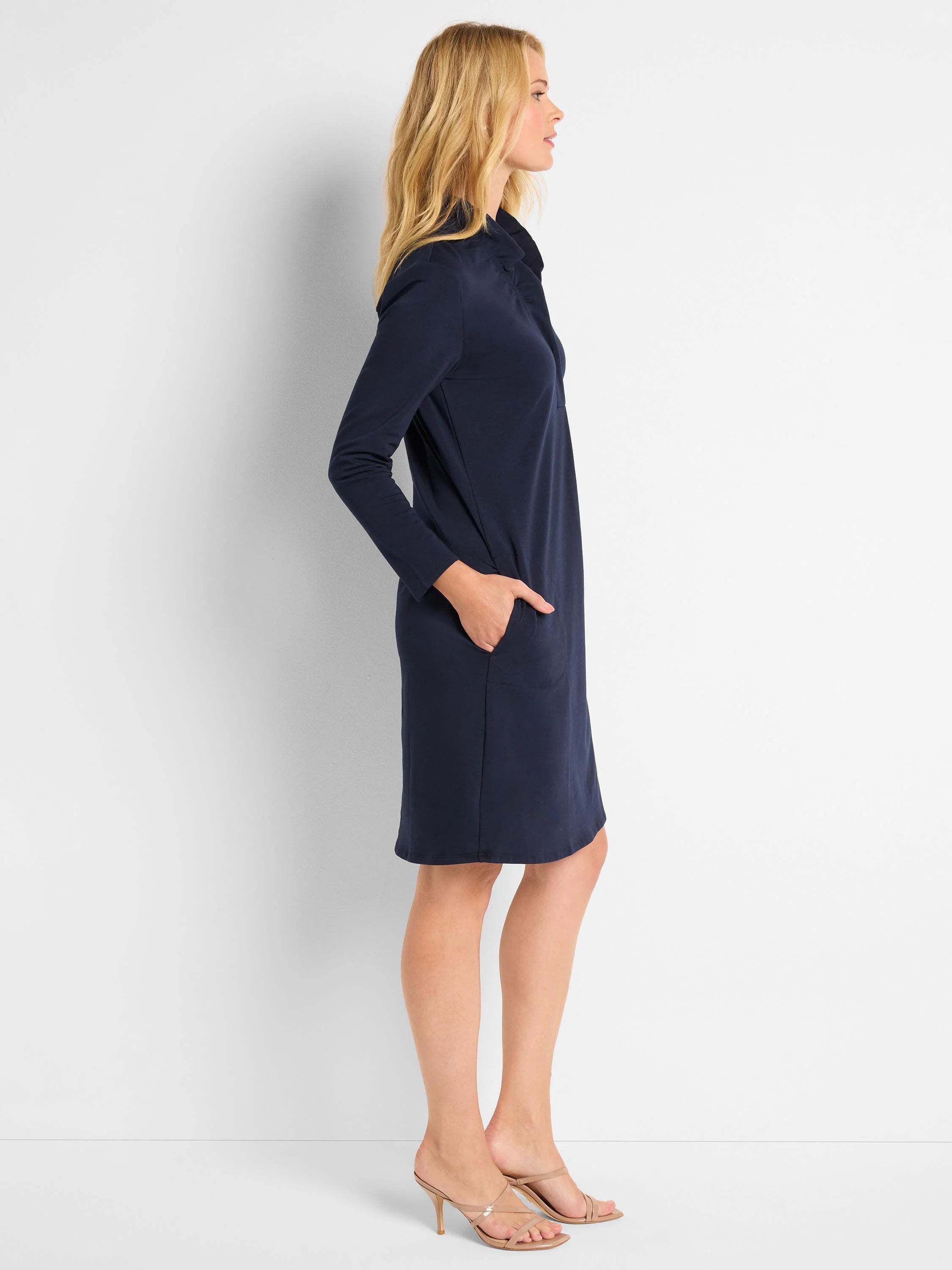 Navy blue knit dress, 3/4 sleeves, ruffled neckline, knee-length, side pockets.