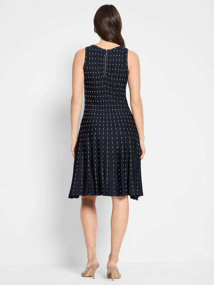 Dark navy sleeveless midi dress with a white dot pattern and a back zipper. A-line silhouette.