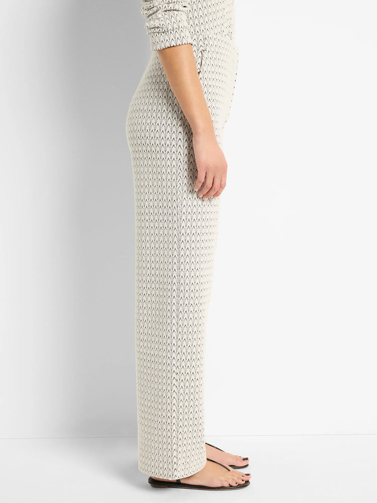 Off-white wide-leg pants with a subtle dark-navy swirl knit pattern. Shown on a model.