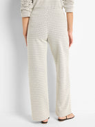 Off-white wide-leg pants with a subtle dark-grey/black repeating swirl pattern.