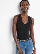 Black wide-leg pants with subtle swirl knit texture.  Model wears a black tank top and blue jeans.