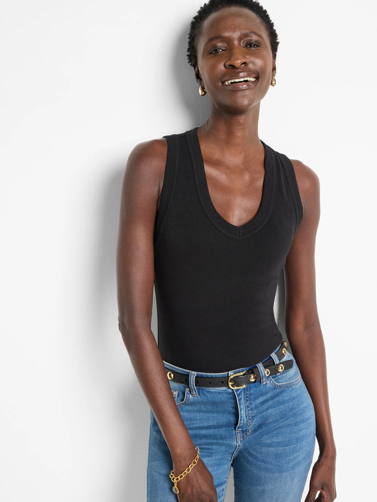 Black wide-leg pants with subtle swirl knit texture. Model wears a black tank top and blue jeans.