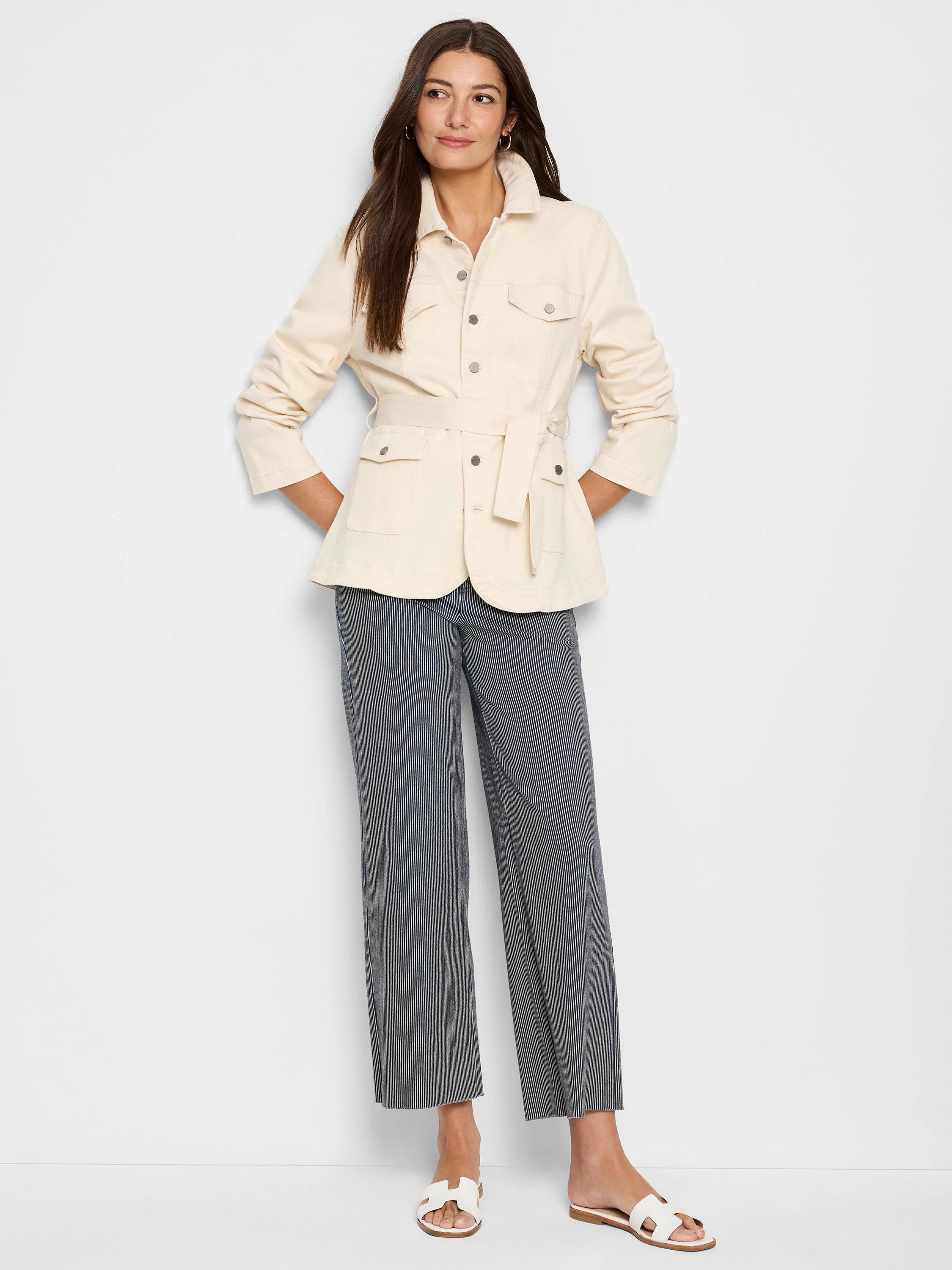 Wide-leg jeans with thin, dark-blue stripes on an off-white background.  Model wears cream-colored jacket.