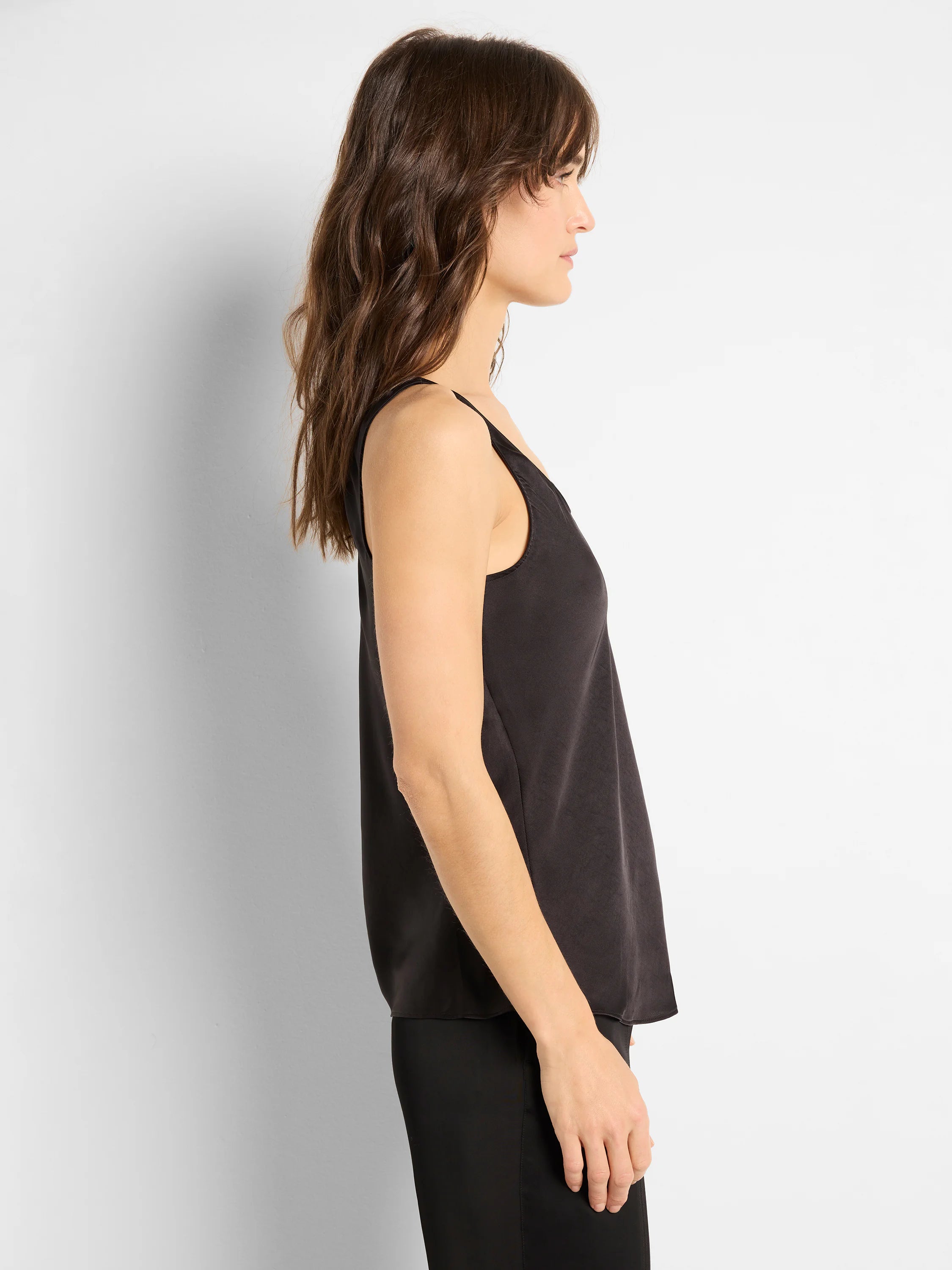Black scoop-neck tank top; woven fabric. Side profile view.