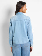 Light blue denim shirt, long sleeves, button front, yoke detail on back. Shown on a model.