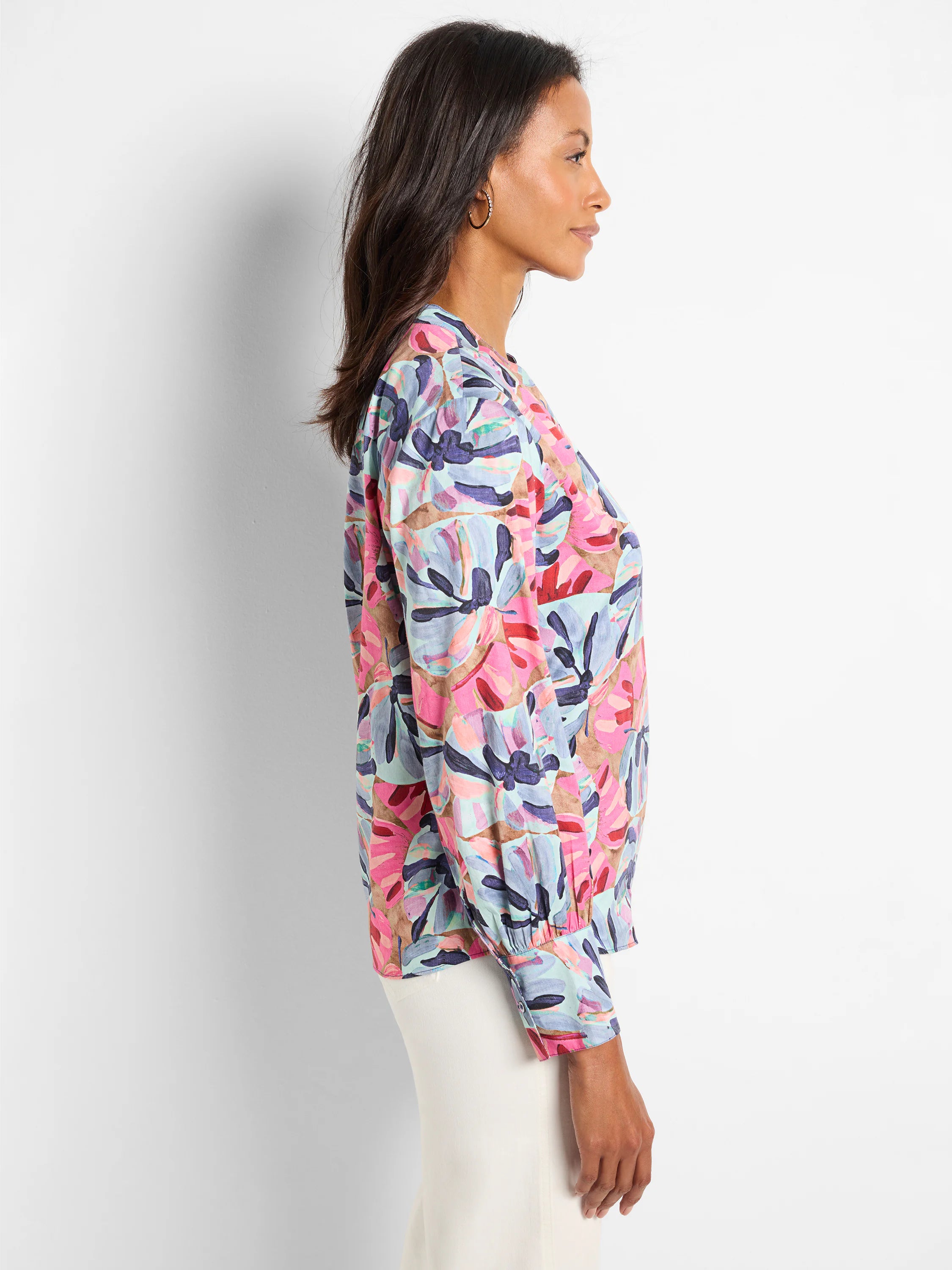 Woven top with long sleeves and a pink, blue, and brown abstract floral print. Puffed sleeves and a round neckline.