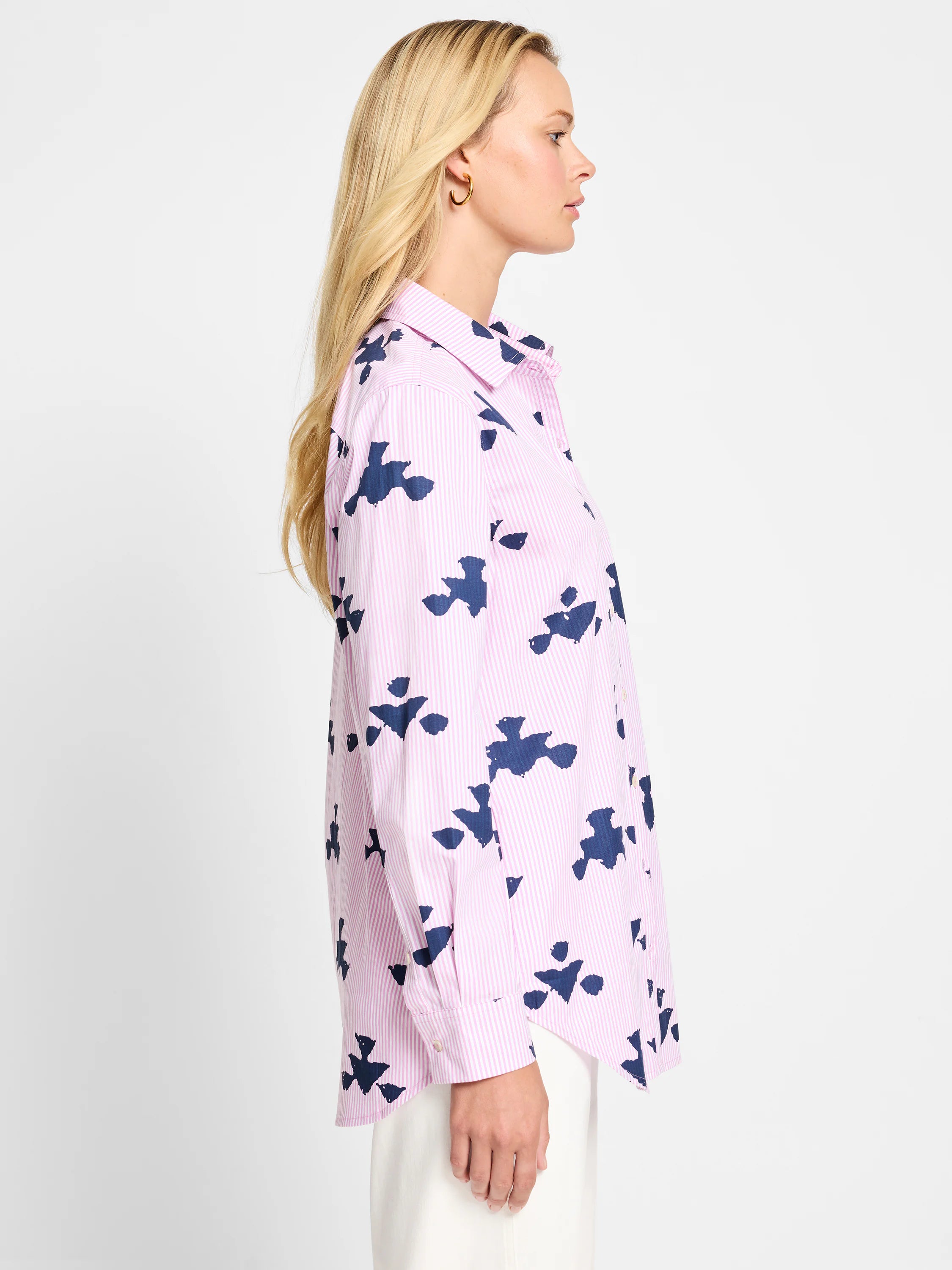 Pink shirt with thin white stripes and a repeated navy blue abstract pattern. Long sleeves, button-down collar.