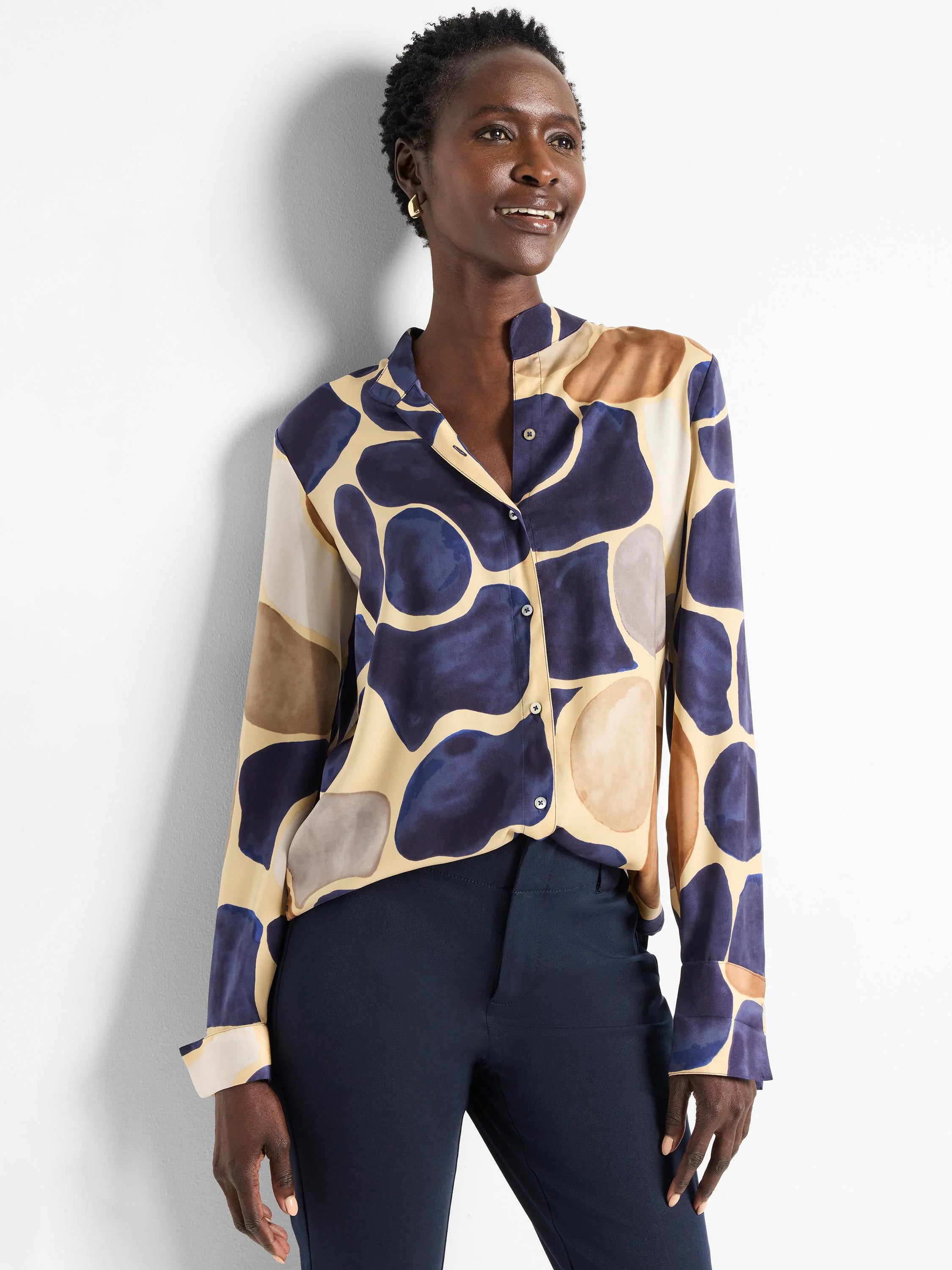 Beige shirt with dark blue, brown, and gray abstract pebble print. Long sleeves, button front.