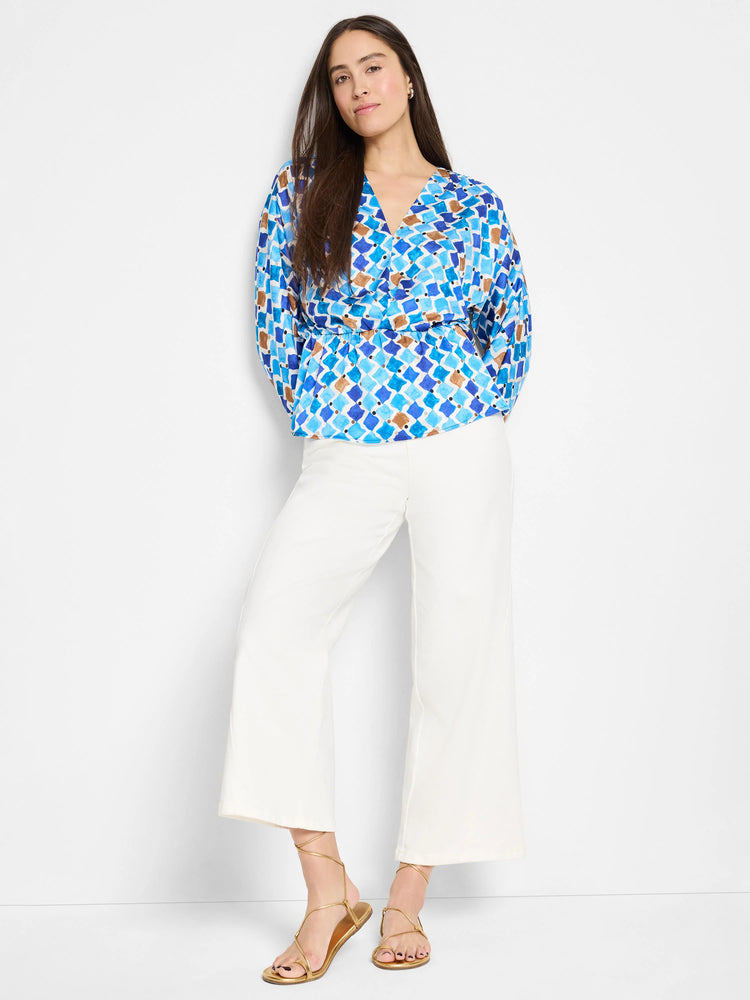 Blue, brown, and white patterned blouse with a V-neck and cinched waist. Three-quarter sleeves.