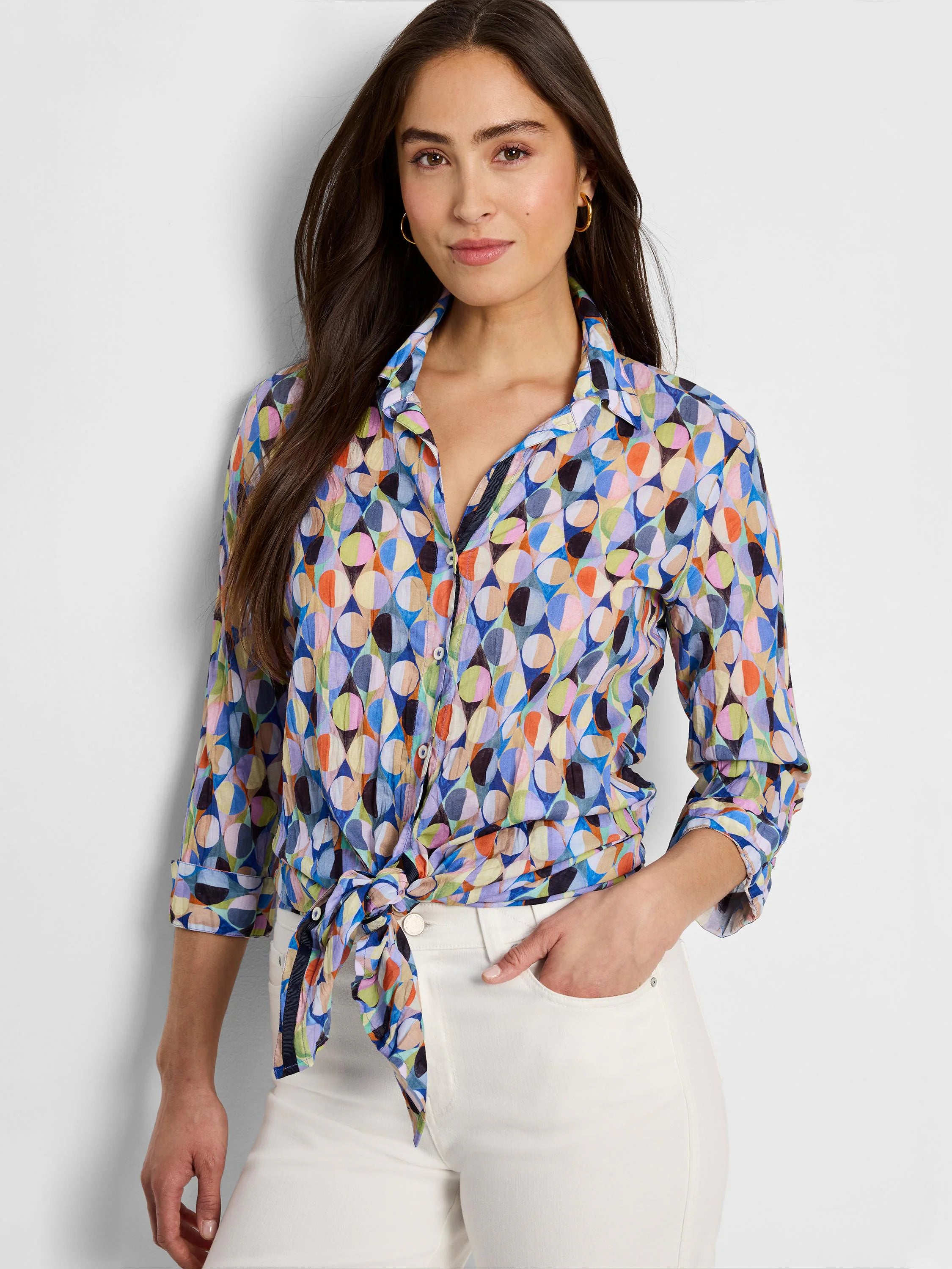 Long-sleeve button-down shirt; blue, beige, pink, green, and black abstract print.  Crinkled fabric, tied at waist.