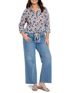 Crinkle shirt with blue, pink, orange, and teal geometric print;  tied at waist.  Model also wears light wash jeans and...