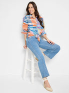 Orange, blue, and beige horizontal stripes on a long-sleeve button-down shirt; knotted at waist.