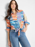 Cotton shirt with orange, blue, purple, and beige stripes in a plaid pattern.  Knotted at waist.